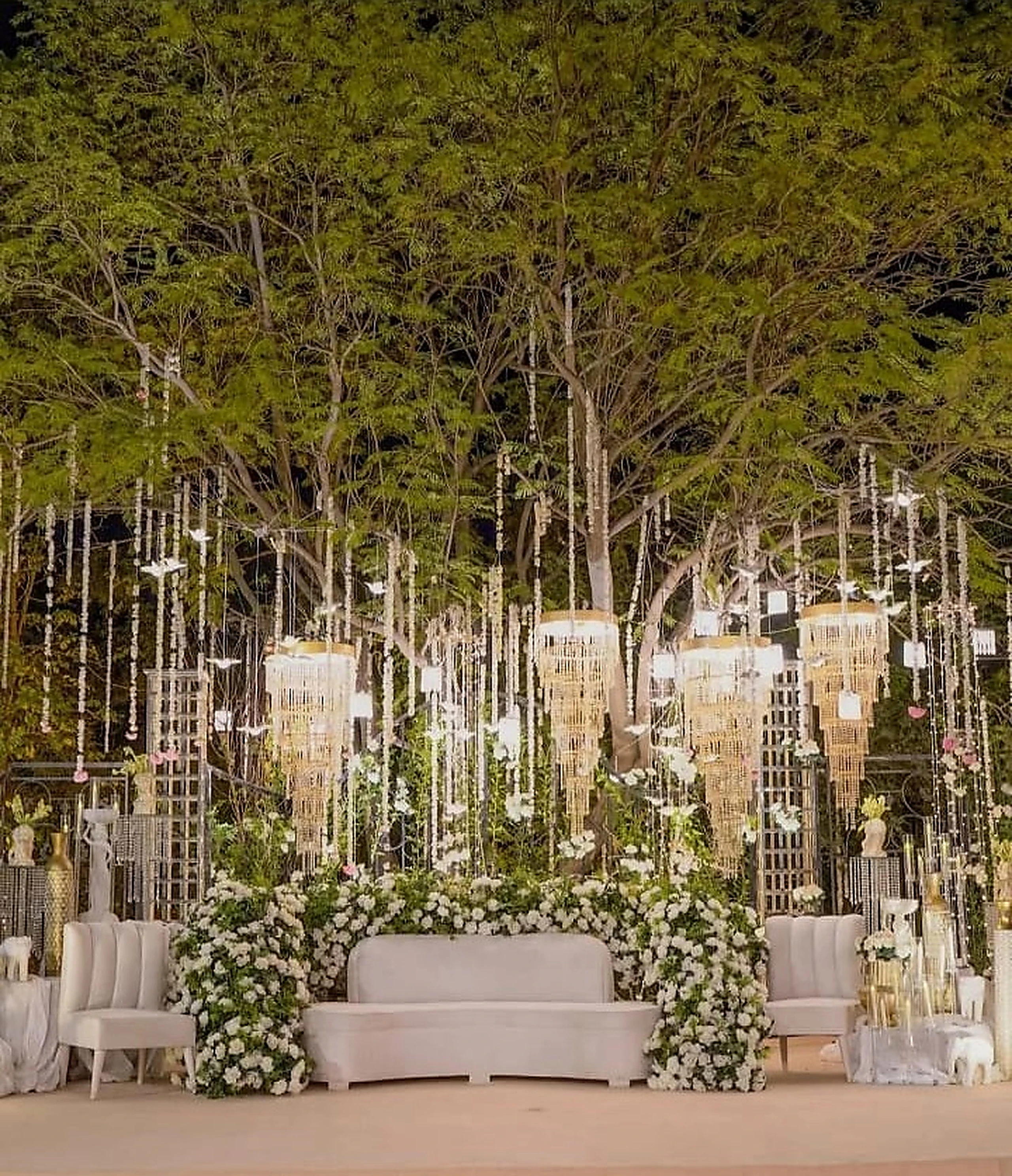 Woodland ceremony set with white seating and vertical crystal installations