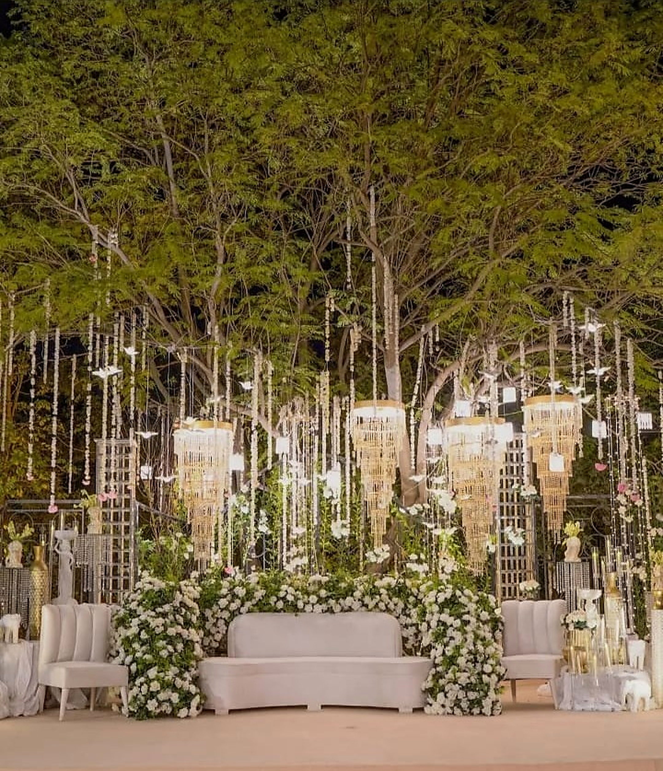 Woodland ceremony set with white seating and vertical crystal installations
